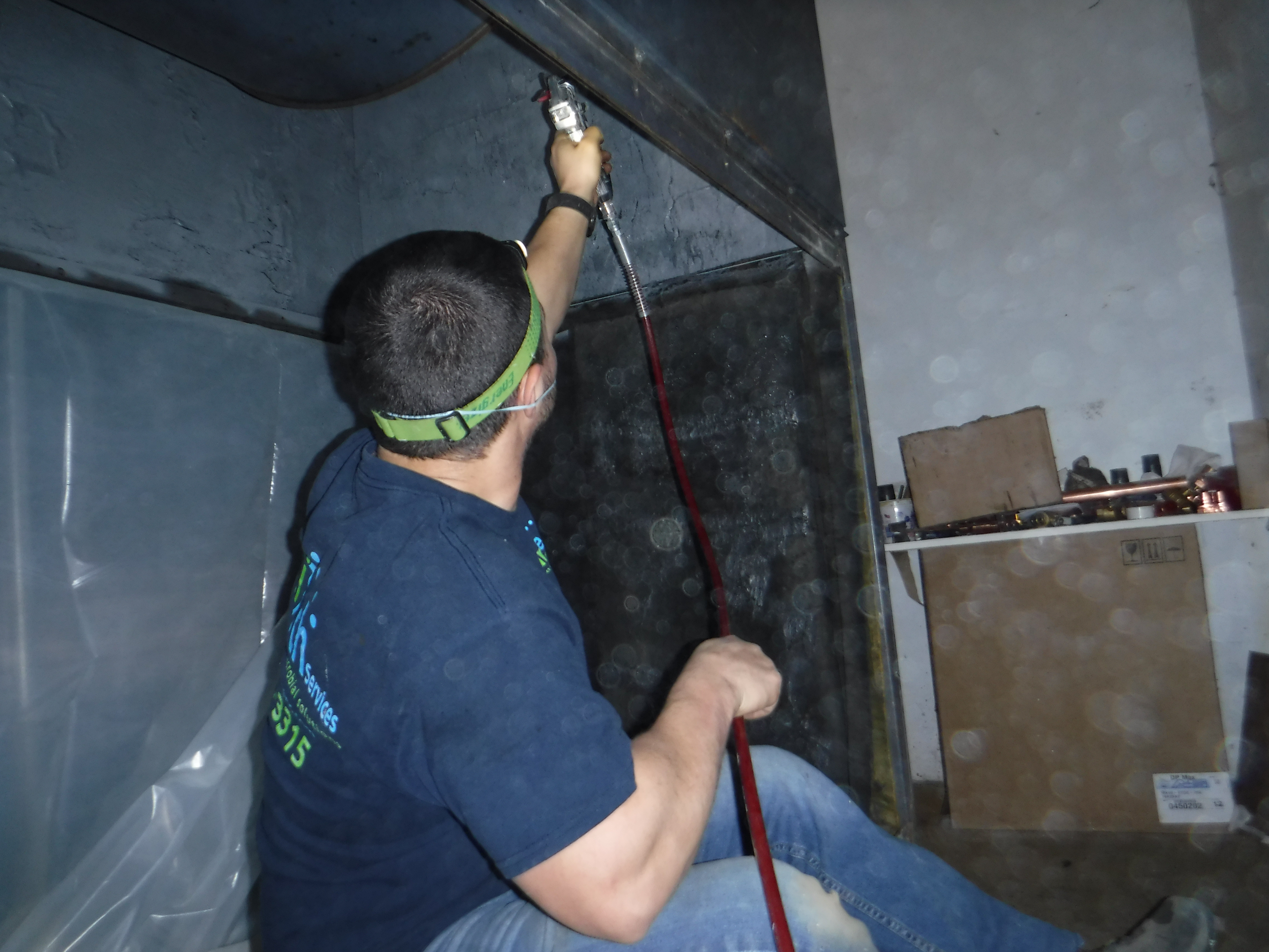 SaniTech technician applying antimicrobial spray inside HVAC ductwork